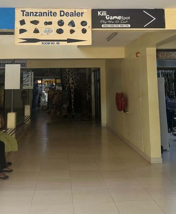 The “Tanzanite Dealer” sign pointing to Room No. 4B in the Kibo Tower corridor