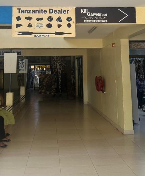 The “Tanzanite Dealer” sign pointing to Room No. 4B in the Kibo Tower corridor